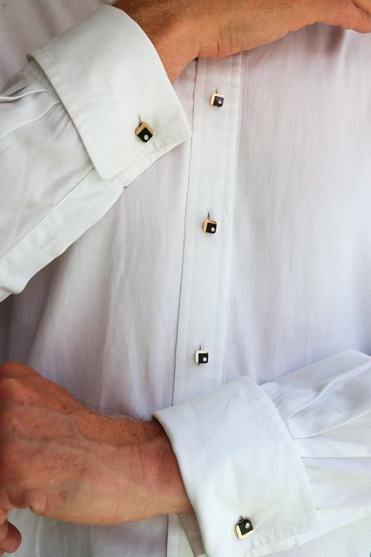 A square yellow gold, black onyx and diamond dress-set, with one white gold stud, modelled in a white shirt