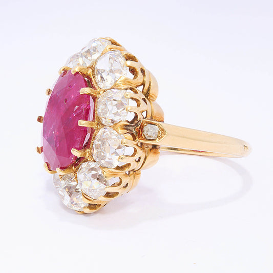 A French antique cushion-cut ruby and diamond oval-shaped cluster ring, with ten, old-cut diamonds in claw settings, mounted in yellow gold, with a French eagle head mark, for 18ct gold, circa 1890.