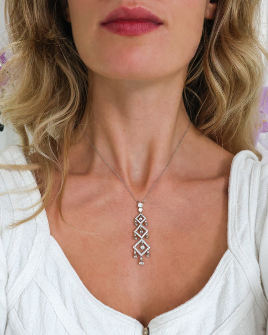 A triple drop diamond set pendant in platinum, on a platinum chain, modelled