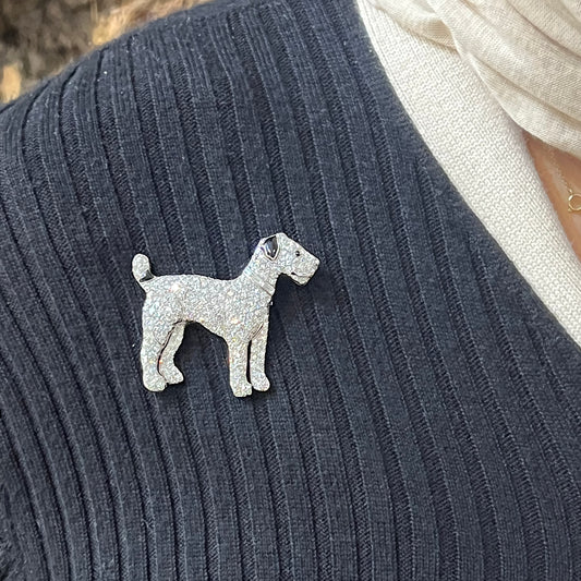 A diamond set terrier dog brooch with black onyx details, in platinum modelled on a blue sweater