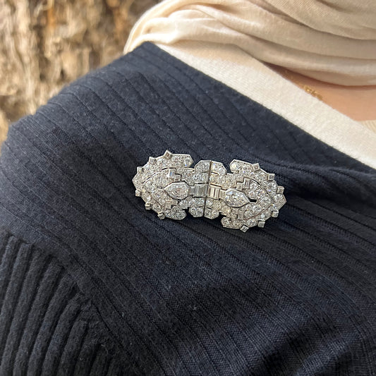 A diamond double clip brooch in platinum and white gold, modelled on a blue sweater