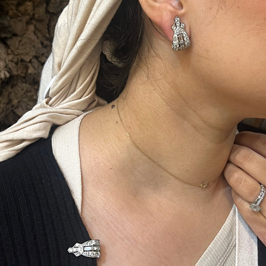 A pair of platinum clips set with round and baguette cut diamonds, modelled as an earring and a brooch