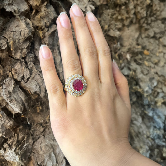An antique cluster ring set with a central ruby, surrounded by diamonds, in yellow gold, modelled on a hand