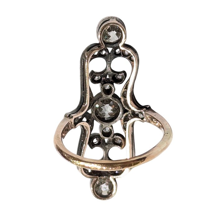 An openwork, decorative antique ring set with diamonds, in gold and silver