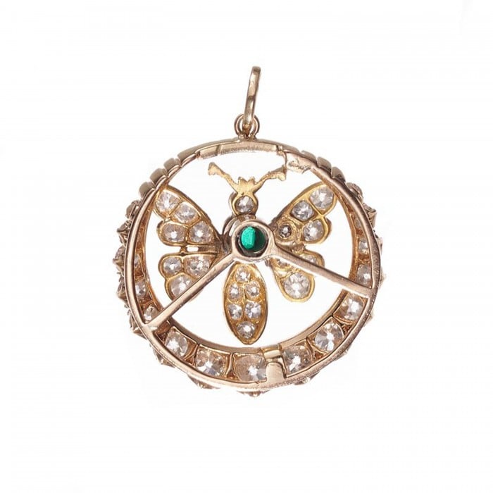 A butterfly open circle pendant set with an emerald and diamonds, in yellow gold