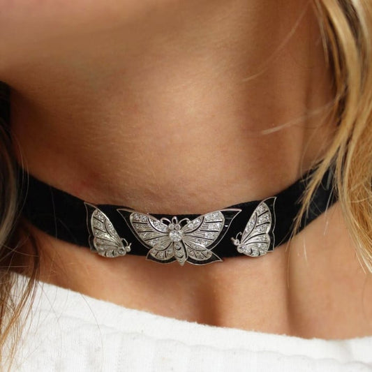 A black choker necklace with a diamond, onyx and platinum butterfly slider, modelled