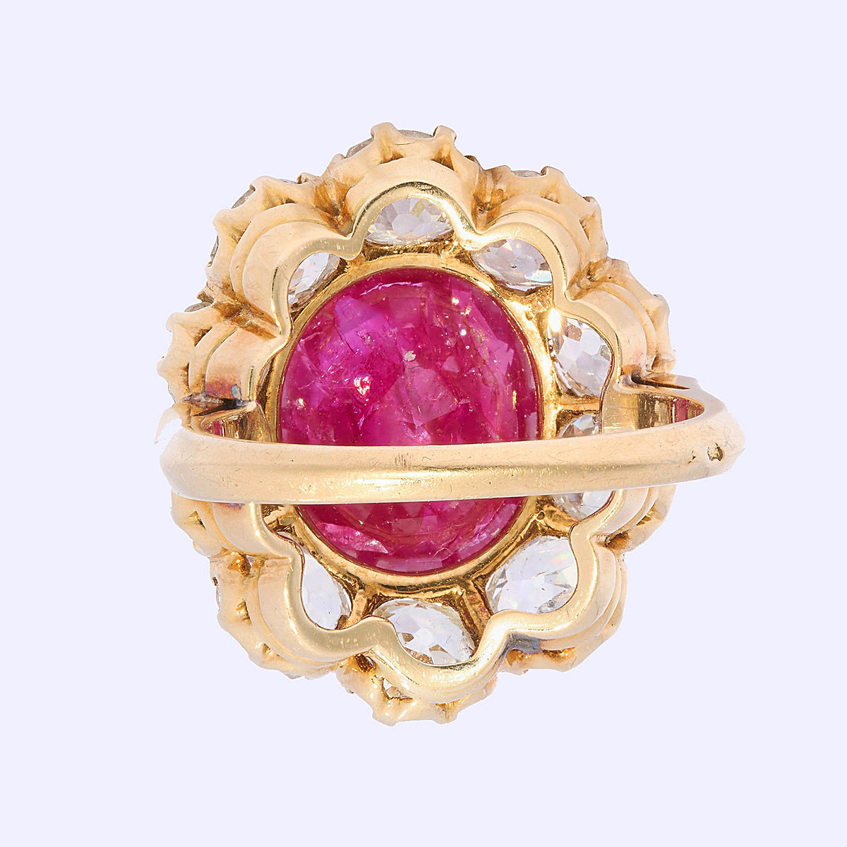 A French antique cushion-cut ruby and diamond oval-shaped cluster ring, with ten, old-cut diamonds in claw settings, mounted in yellow gold, with a French eagle head mark, for 18ct gold, circa 1890.