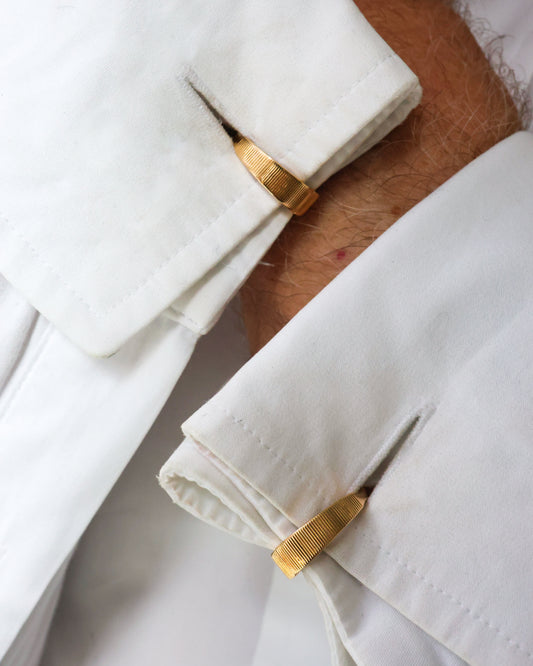 A pair of yellow and white gold stirrup cufflinks, modelled in white shirt cuffs