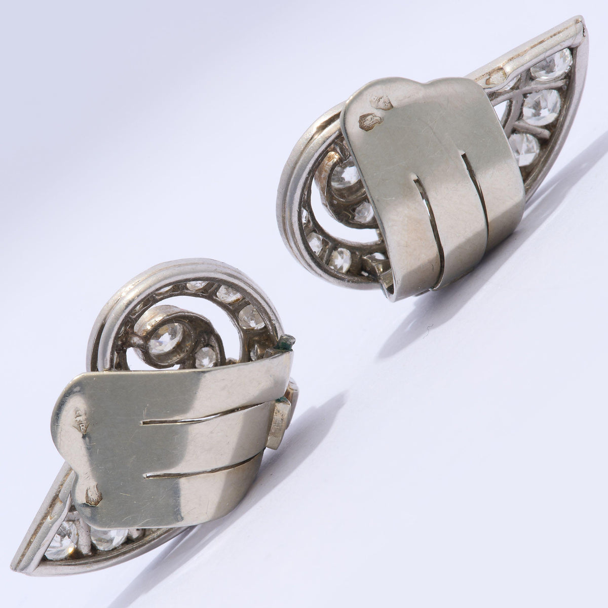 A pair of round diamond shell shaped earrings in platinum, with white gold clip-on fittings