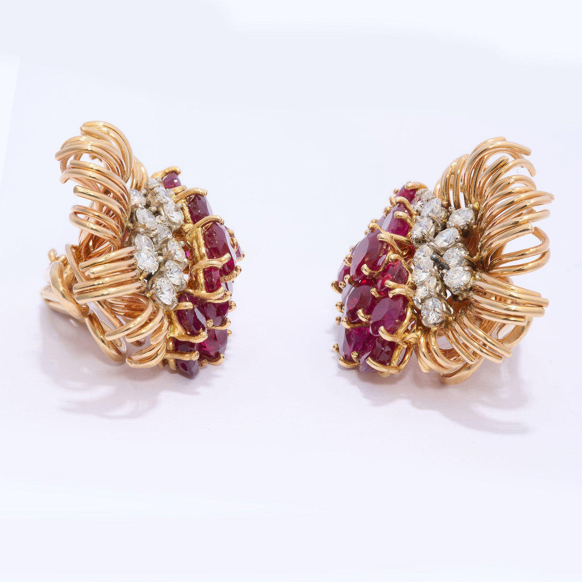 A pair of round ruby and round diamond floral spray earrings in yellow gold
