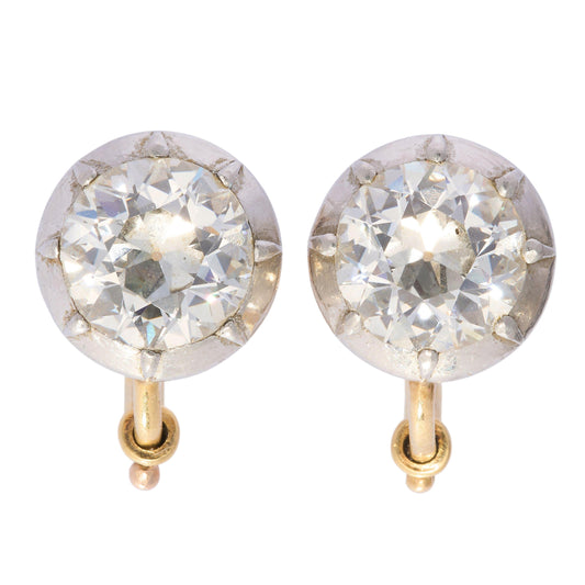 A pair of old cut diamond single stone earrings in silver, with yellow gold hinged clip on fittings
