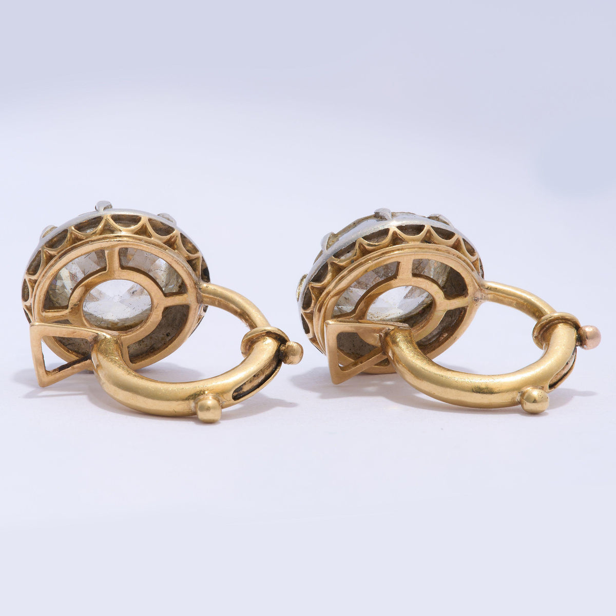 A pair of old cut diamond single stone earrings in silver, with yellow gold hinged clip on fittings