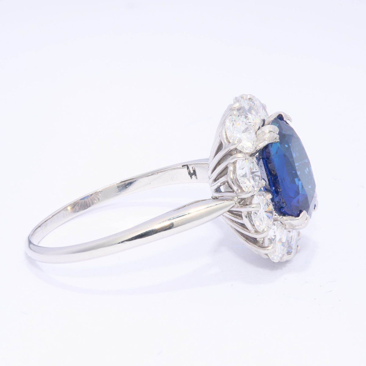 An oval sapphire and round diamond claw set cluster ring in platinum