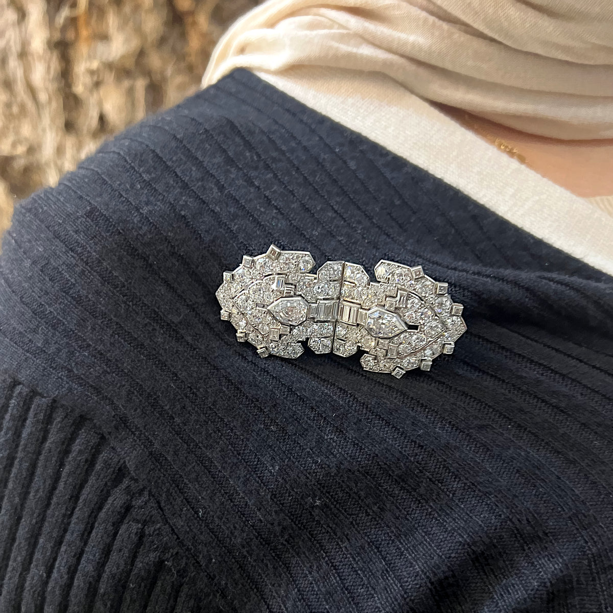 A diamond double clip brooch in platinum and white gold, modelled on a blue sweater
