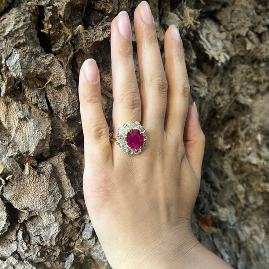 A French antique cushion-cut ruby and diamond oval-shaped cluster ring, with ten, old-cut diamonds in claw settings, mounted in yellow gold, modelled on a hand