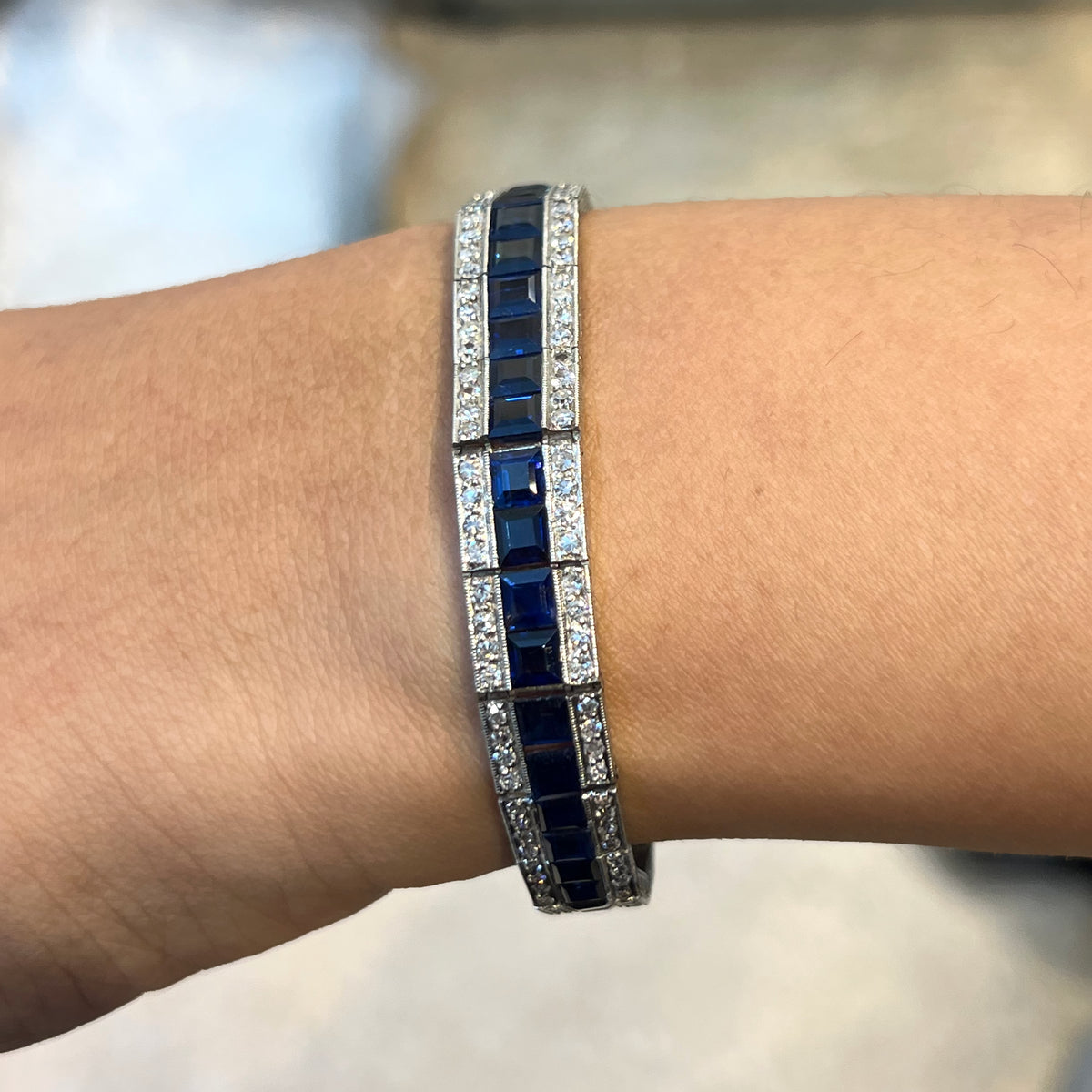 A three row sapphire and diamond graduating bracelet in platinum, modelled on a wrist