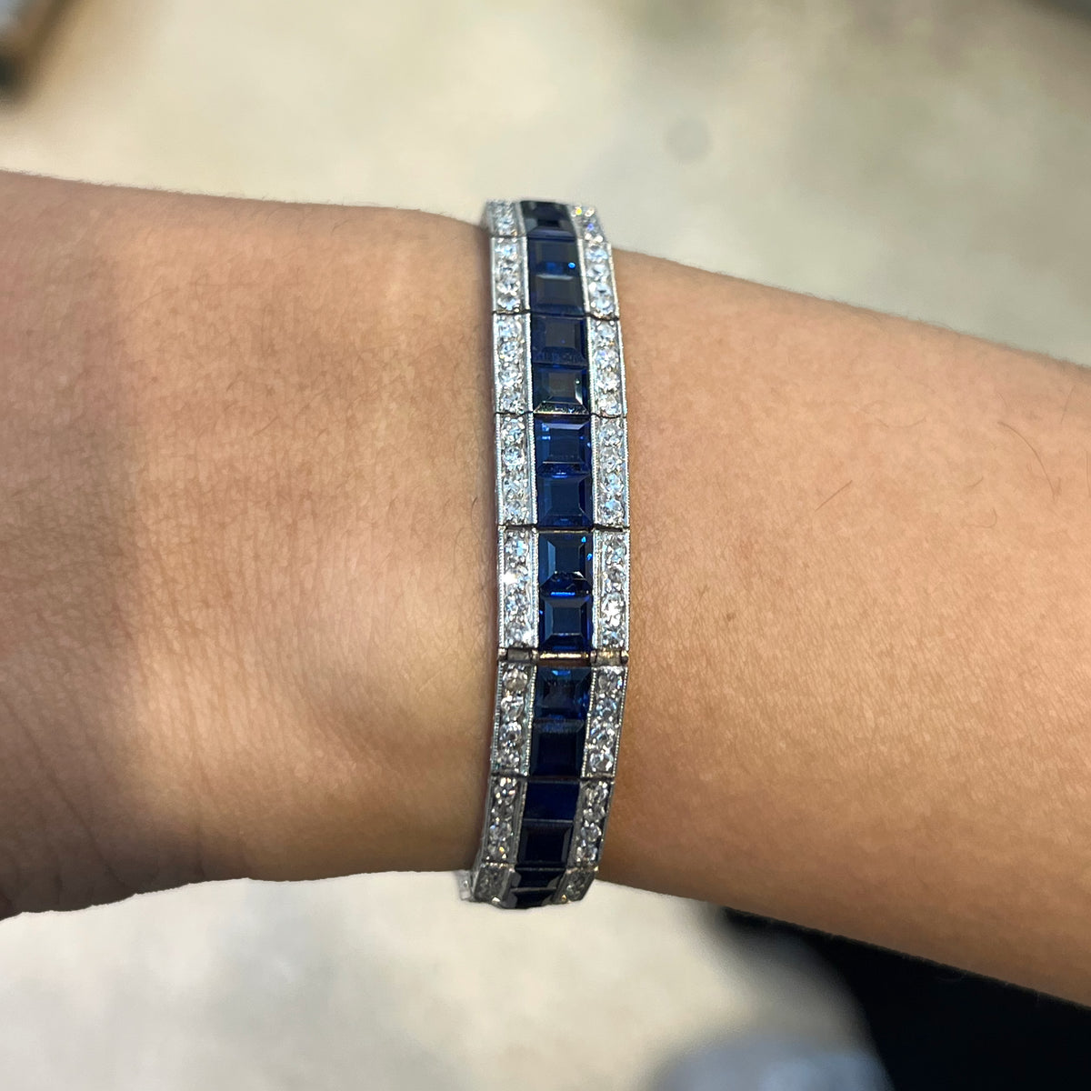 A three row sapphire and diamond graduating bracelet in platinum, modelled on a wrist