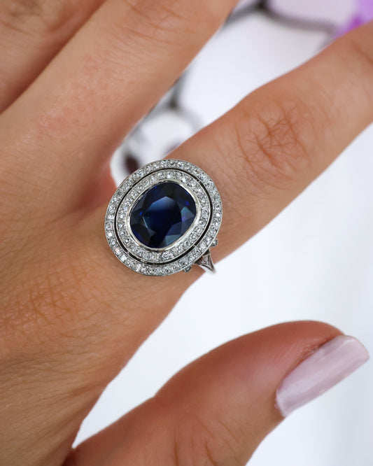 A double row oval sapphire and round diamond cluster ring in platinum, modelled