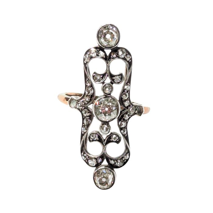 An openwork, decorative antique ring set with diamonds, in gold and silver