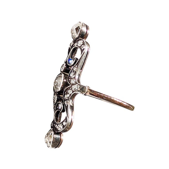 An openwork, decorative antique ring set with diamonds, in gold and silver