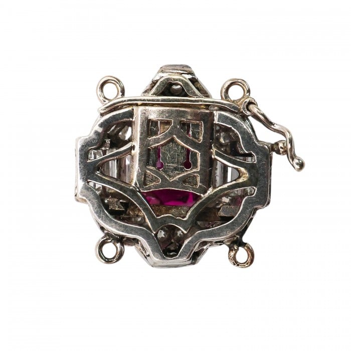 A ruby and diamond clasp in white metal