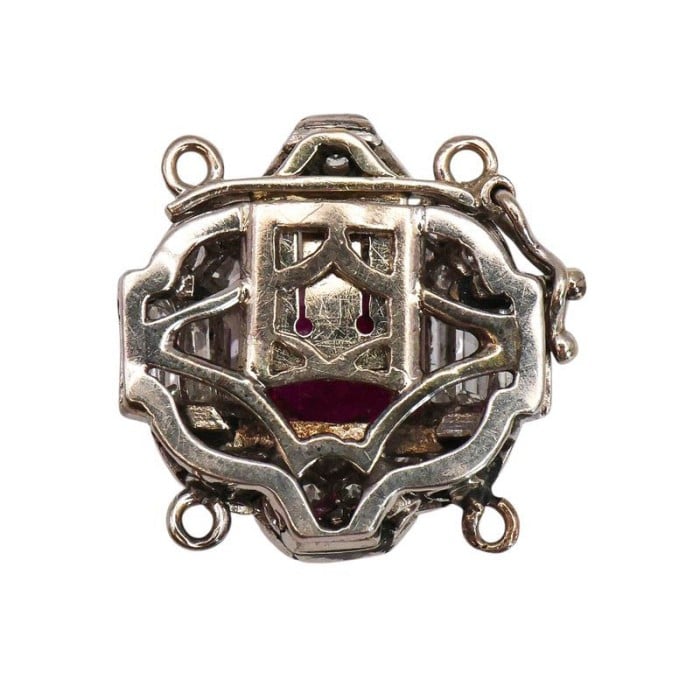 A ruby and diamond clasp in white metal