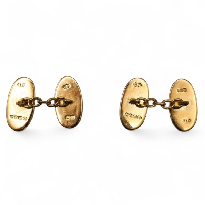A pair of oval plain yellow gold cufflinks, hallmarked to the reverse