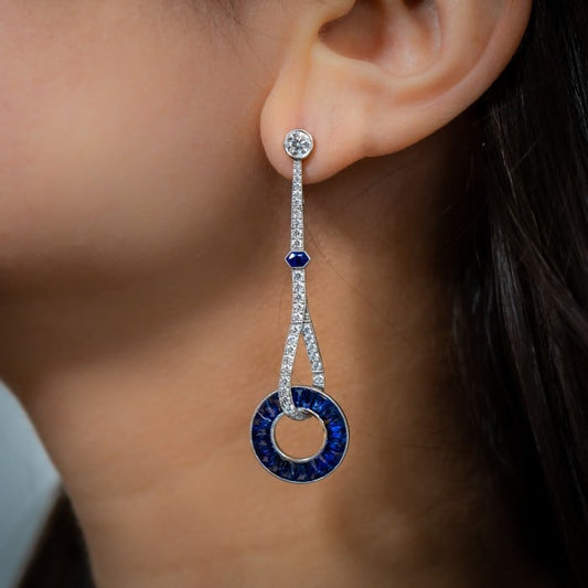 A long drop earring with sapphires and diamonds, in platinum, modelled in an ear