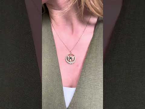 Video of a butterfly open circle pendant set with an emerald and diamonds, in yellow gold
